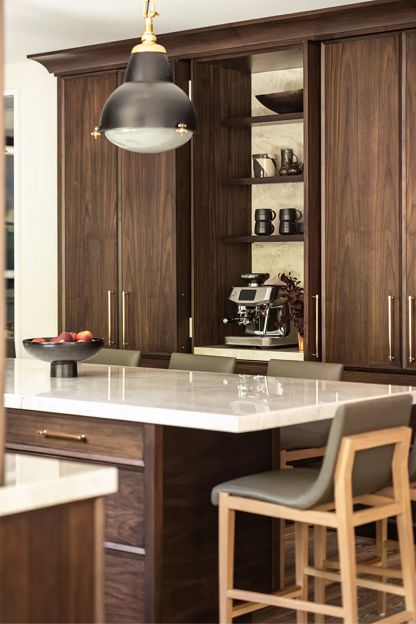 Luxury kitchen with hidden coffee station, custom walnut cabinetry, and marble island