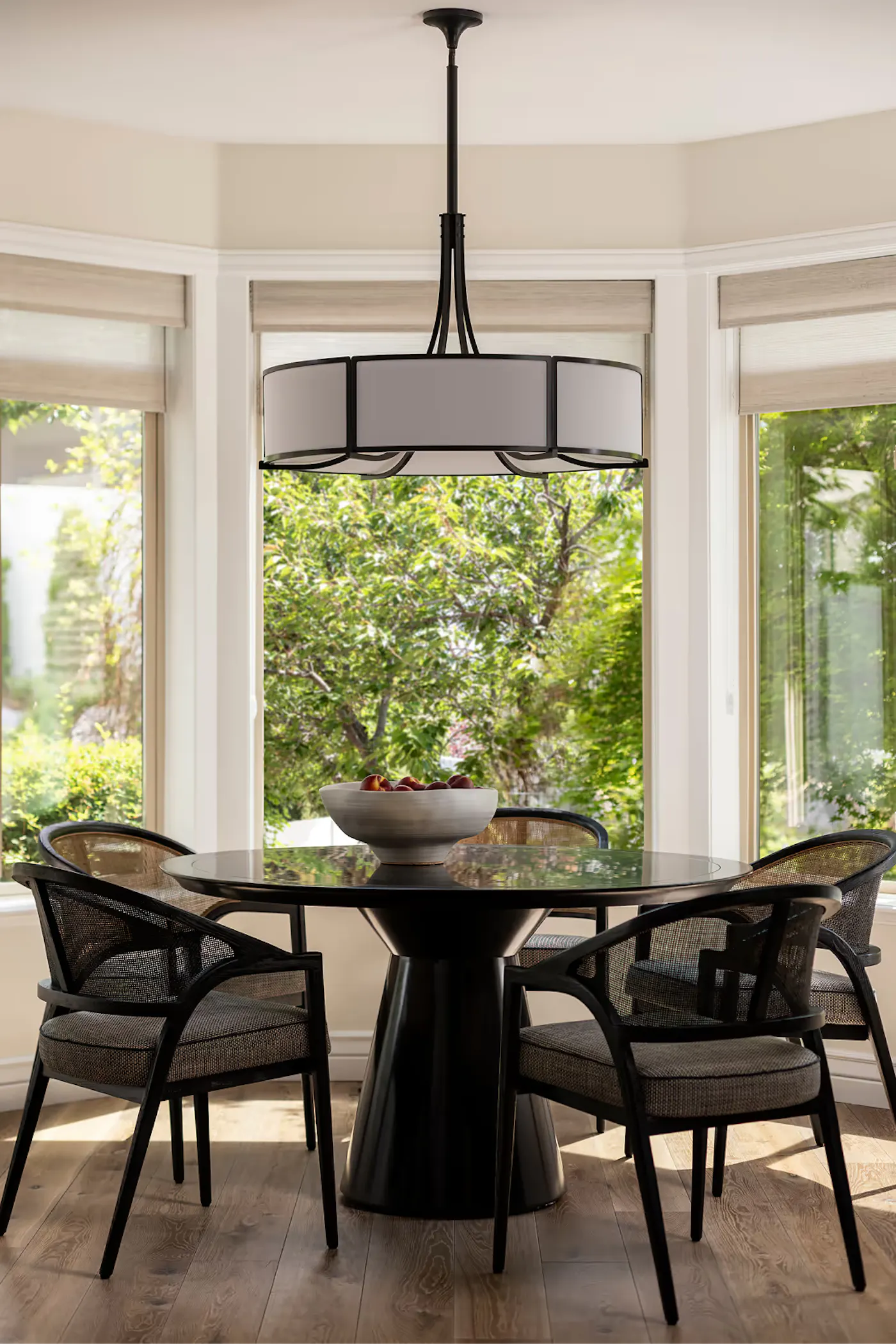 Modern breakfast nook with round table, statement pendant lighting, and natural light