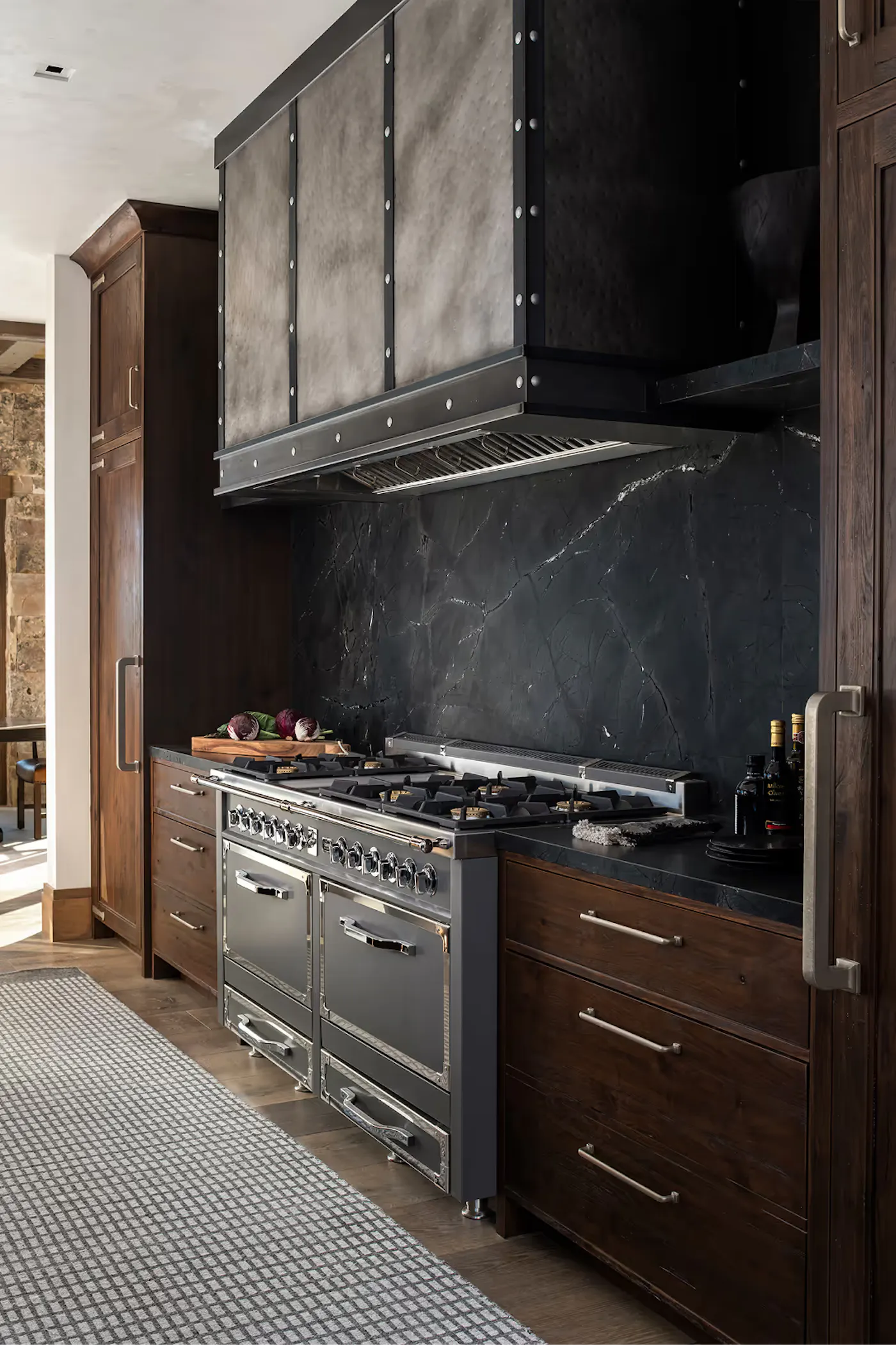 Rustic modern kitchen with oversized range and textured stone backsplash
