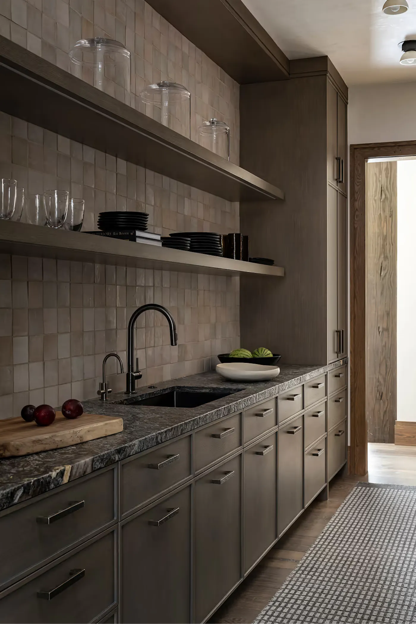 Custom kitchen cabinetry with open shelving and stone countertop
