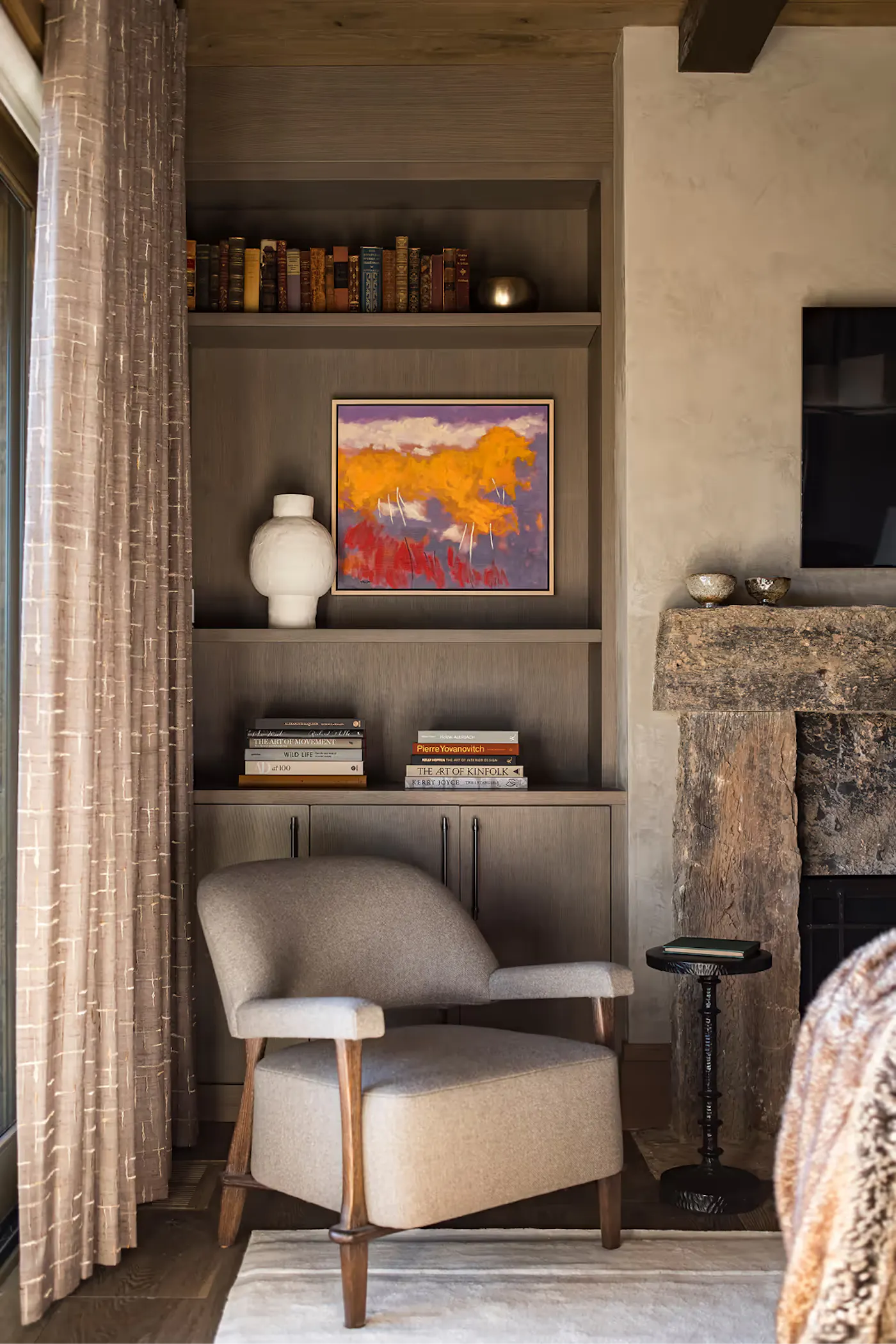 Custom built-in shelving with lounge chair and curated styling in a mountain modern interior