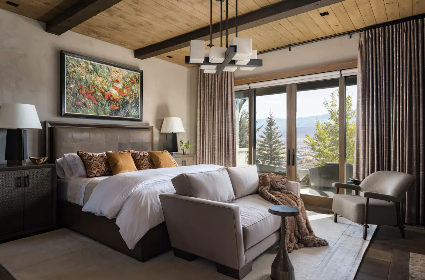 Mountain modern bedroom with exposed wood beams and panoramic valley views