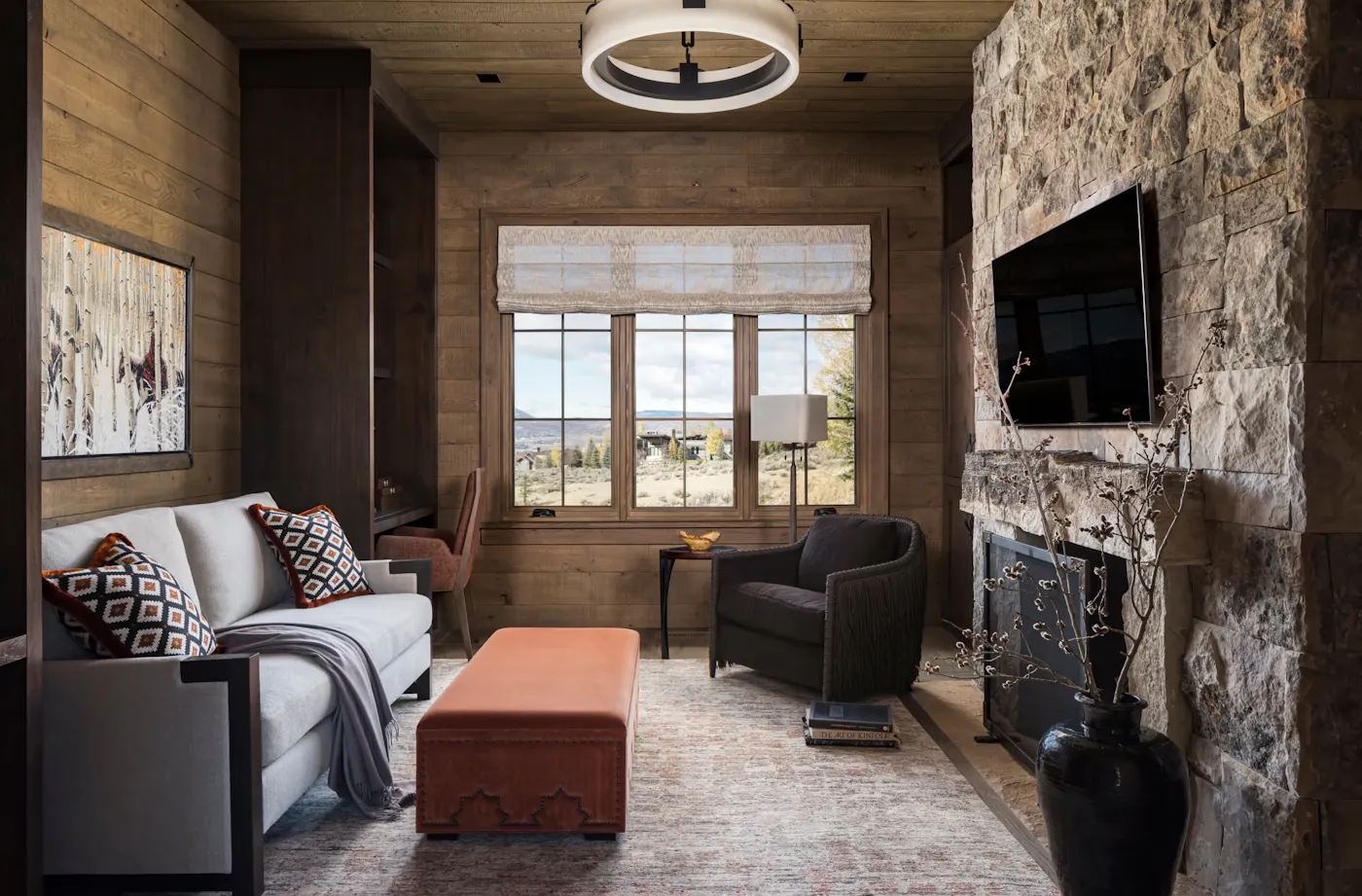 Cozy sitting room with stone fireplace and custom wood detailing