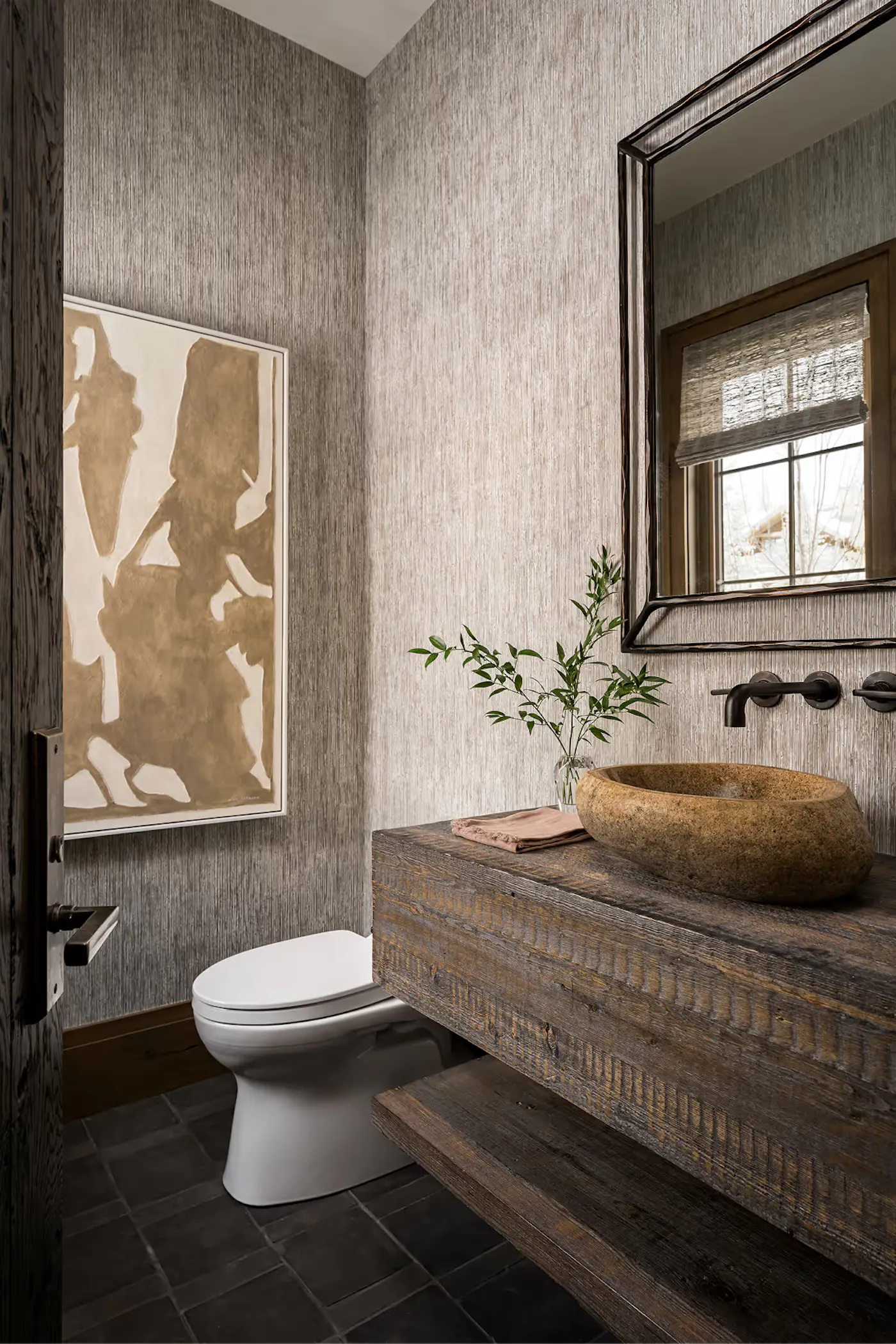 Bathroom interior design with floating wood vanity and stone vessel sink