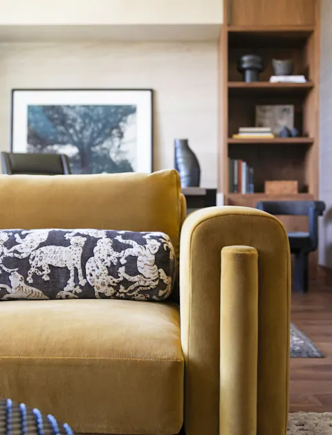 Contemporary living room detail with mustard velvet sofa and custom shelving by Leslie Schofield Studio