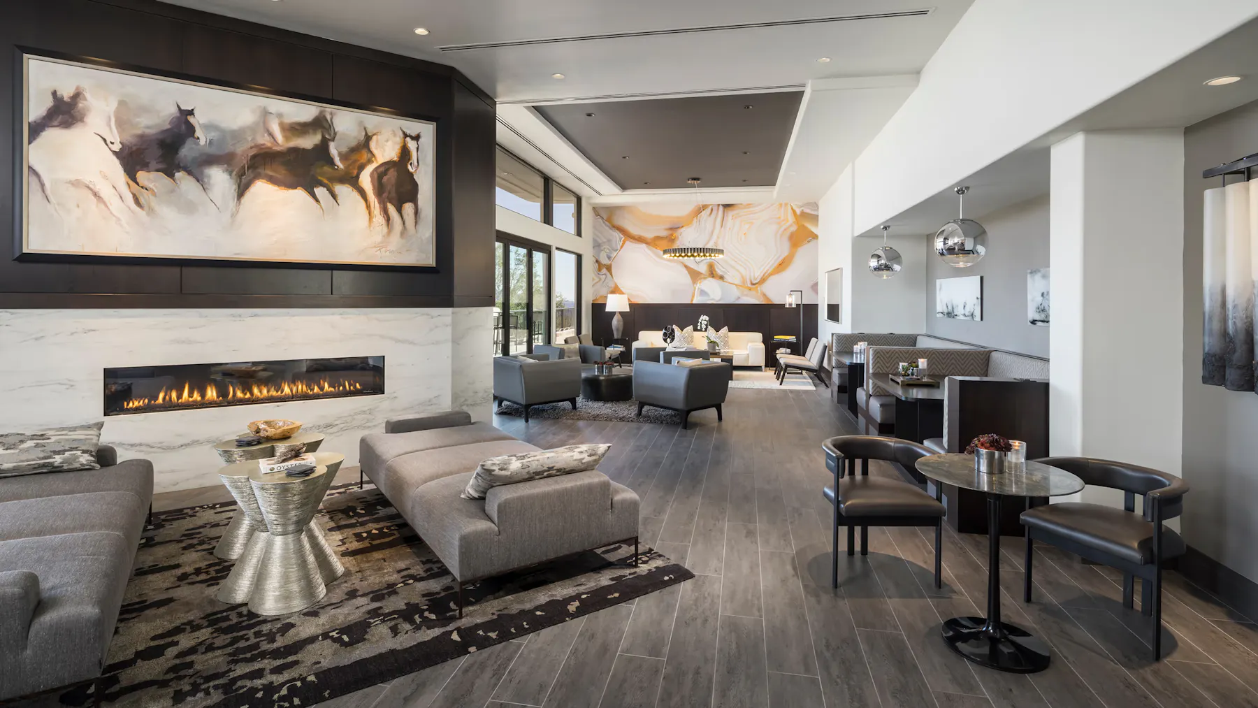 Sophisticated open concept living space with custom fireplace surround, upscale furnishings, and elegant lounge areas