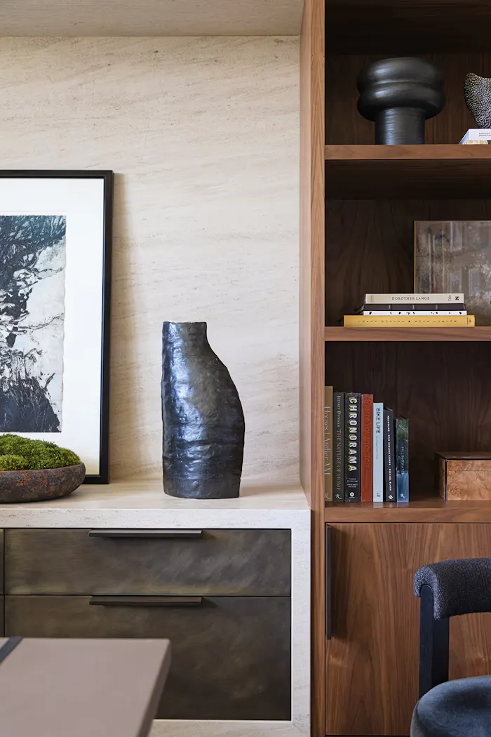 Elegant interior styling detail featuring custom wood built-ins, modern decor objects, and refined neutral stone finishes