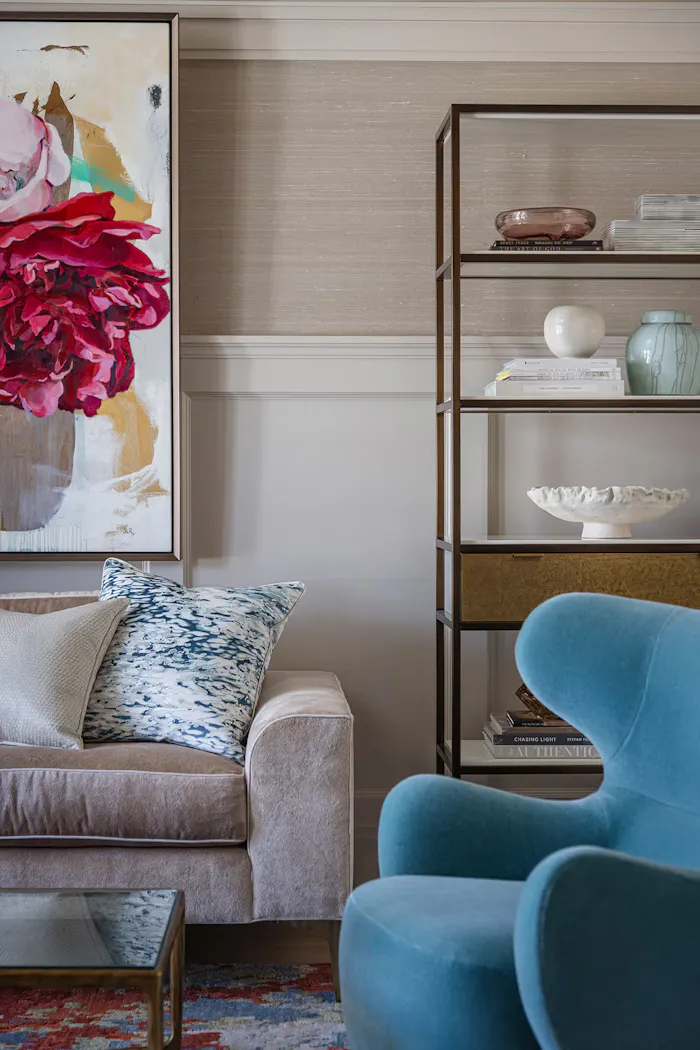 Contemporary luxury living space featuring layered textures, colorful abstract floral painting, and sophisticated interior decor accents