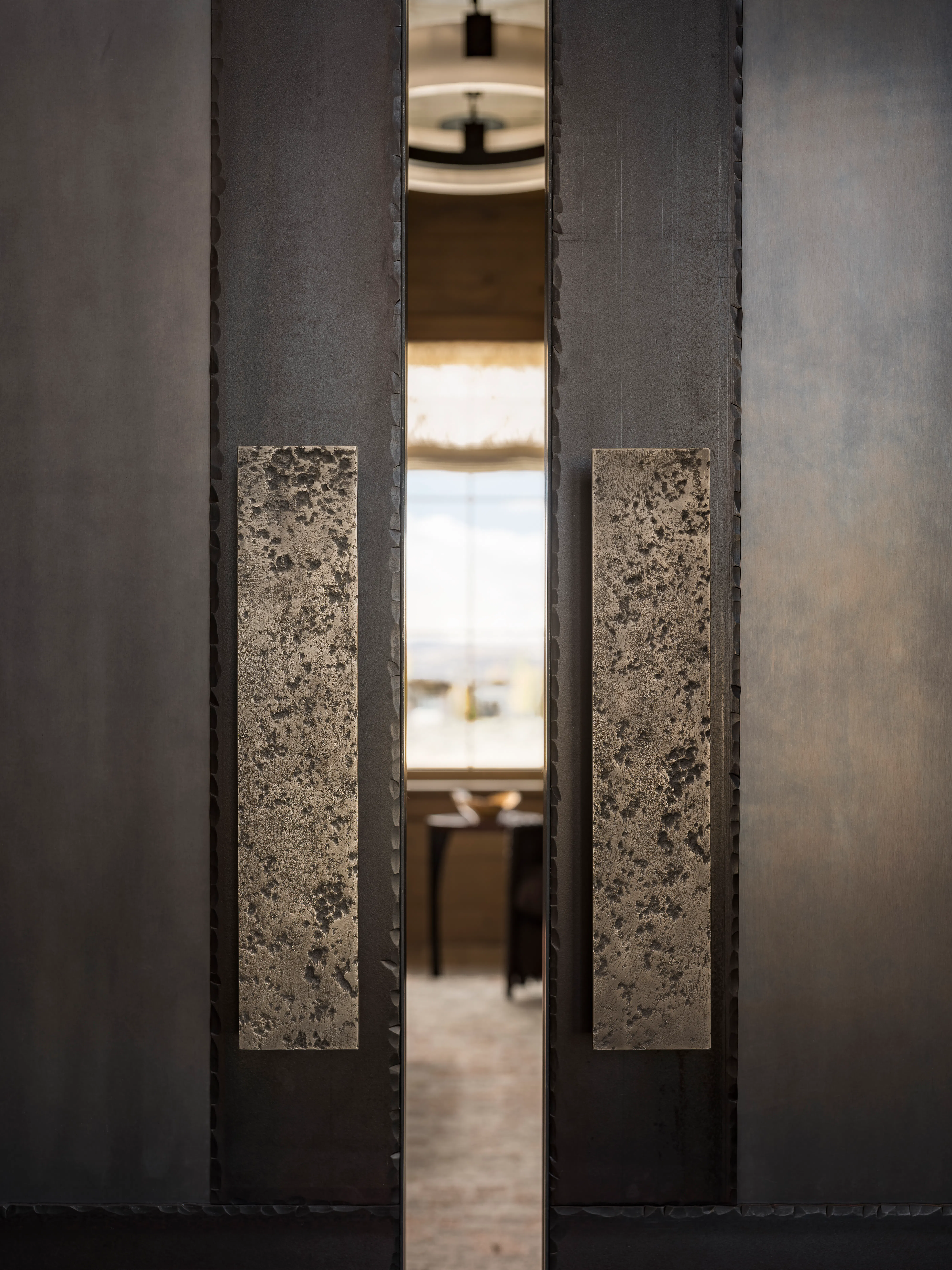 Custom steel door handles on door cracked open with a sliver of view into home office. 