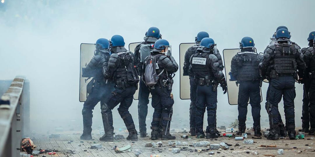 Des gendarmes mobiles lors d'une opération de maintien de l'ordre à Paris. Au sol, les restes de projectiles jetés sur eux mais également de grenades lacrymogènes et de désencerclement. (Photo: norbu-gyachung / unsplash)