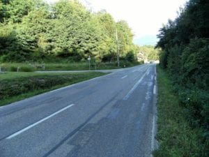 La salle des fêtes est située au bout de la ligne droite, à gauche, dans le virage de la route principale qui relie les départements de l’Ain et de la Savoie. Cette photo montre qu’elle est située à la sortie de la ville et qu’elle est entourée d’une nature dense et difficile d’accès. Photo d'illustration (A.V/L'Essor).