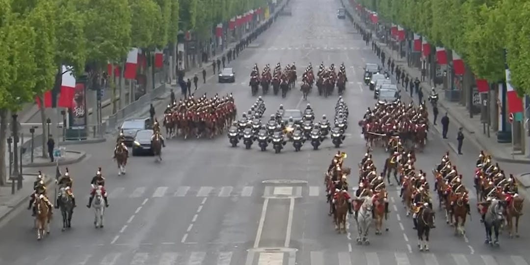 Le régiment de cavalerie de la Garde républicaine, encadrant la voiture du Président de la République, sur les Champs-Elysées (Capture d'écran de la retransmission télévisée de la cérémonie commémorative du 8 mai 1945, le 8 mai 2022 à Paris).