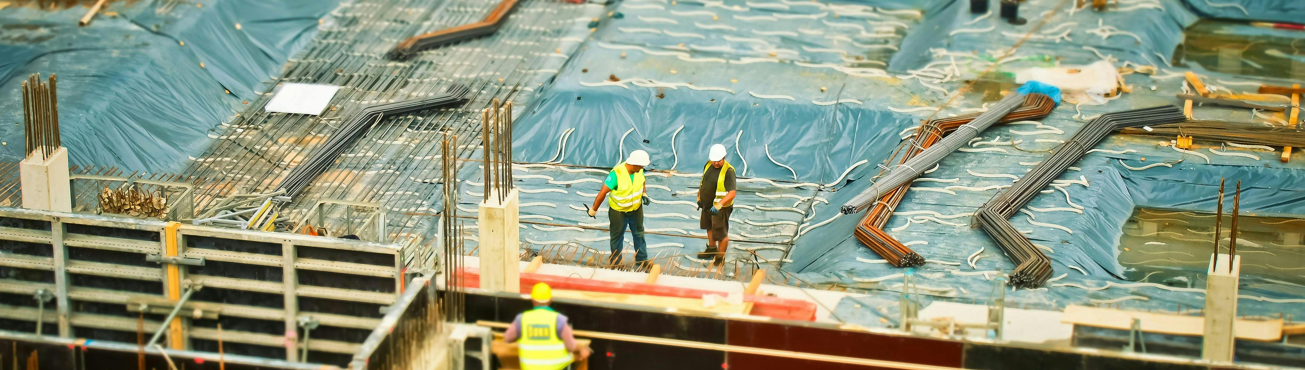 Photo of construction site with workers examining the site
