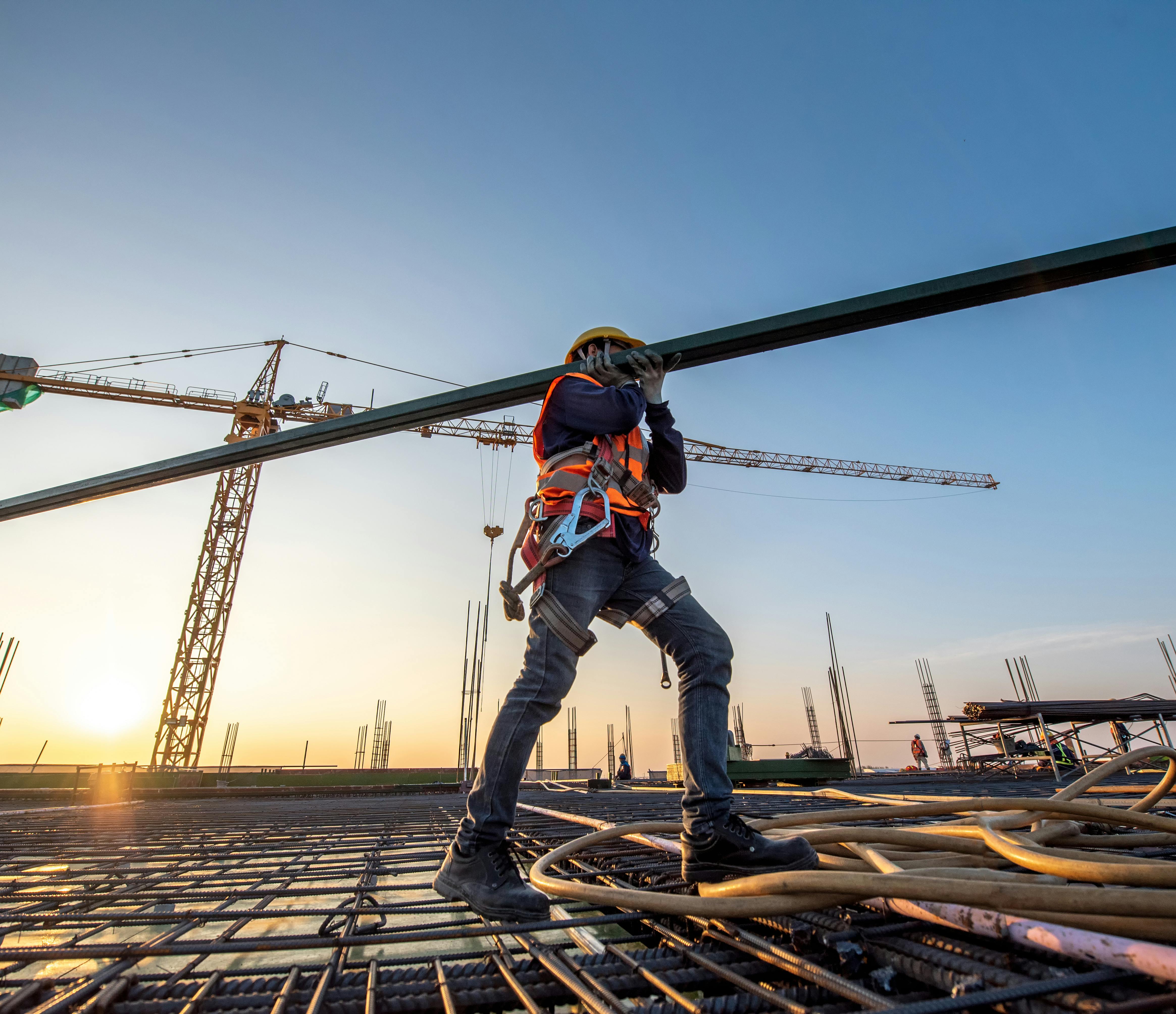 Photo of construction worker carrying supplies on aconstruction site