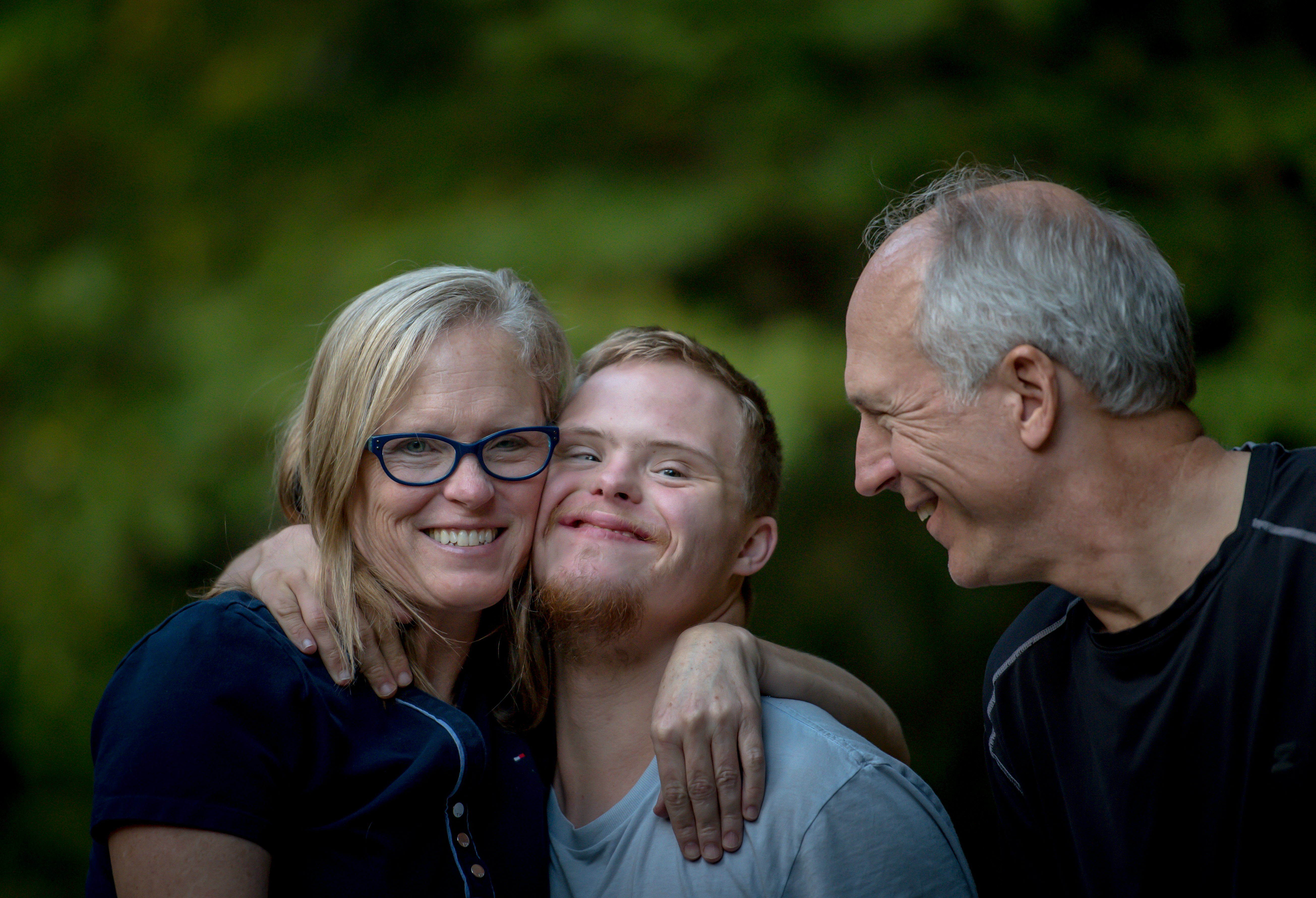 Photo of a mother and father with their son who has Down syndrome