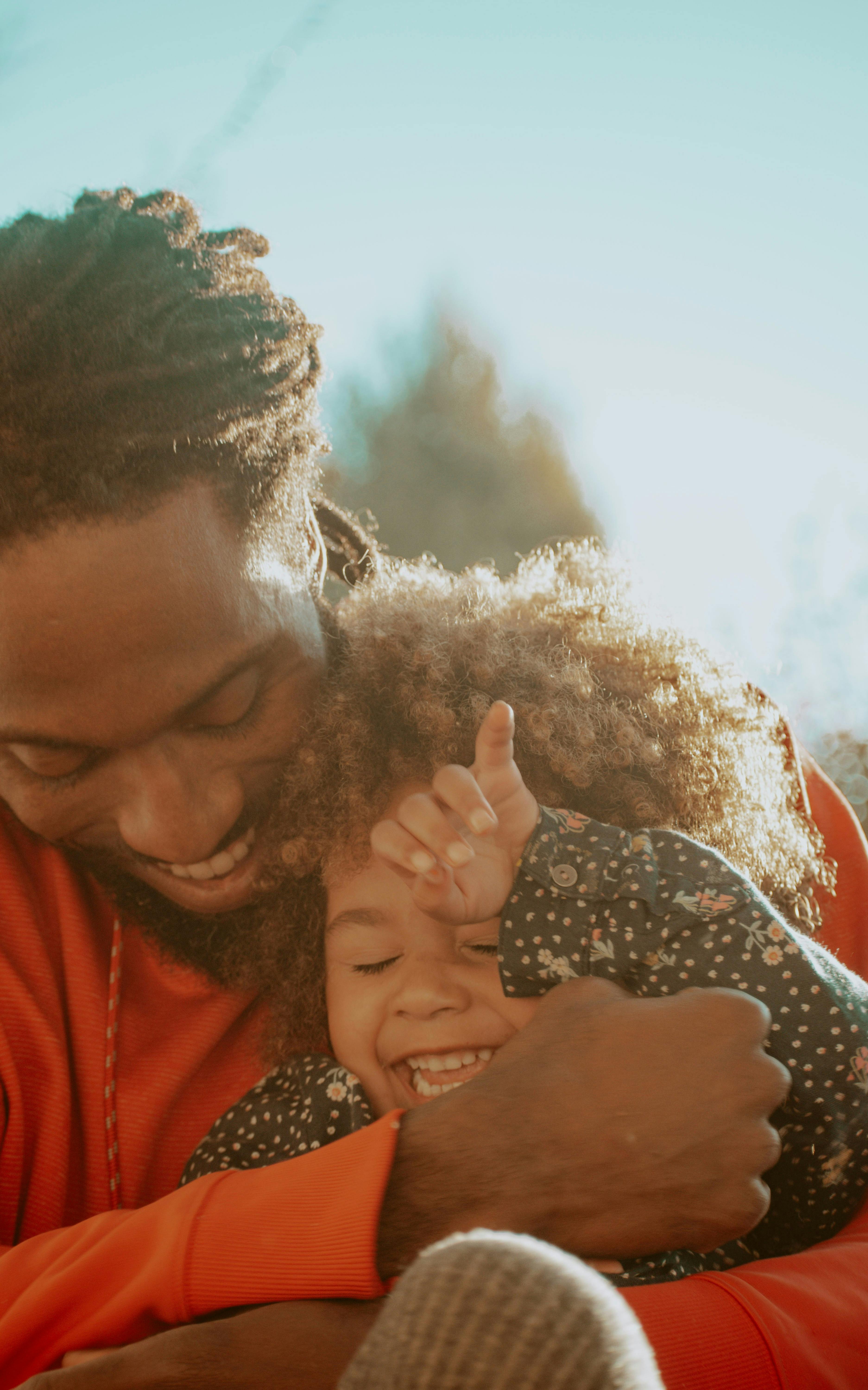 Photo of laughing father holding his smiling son