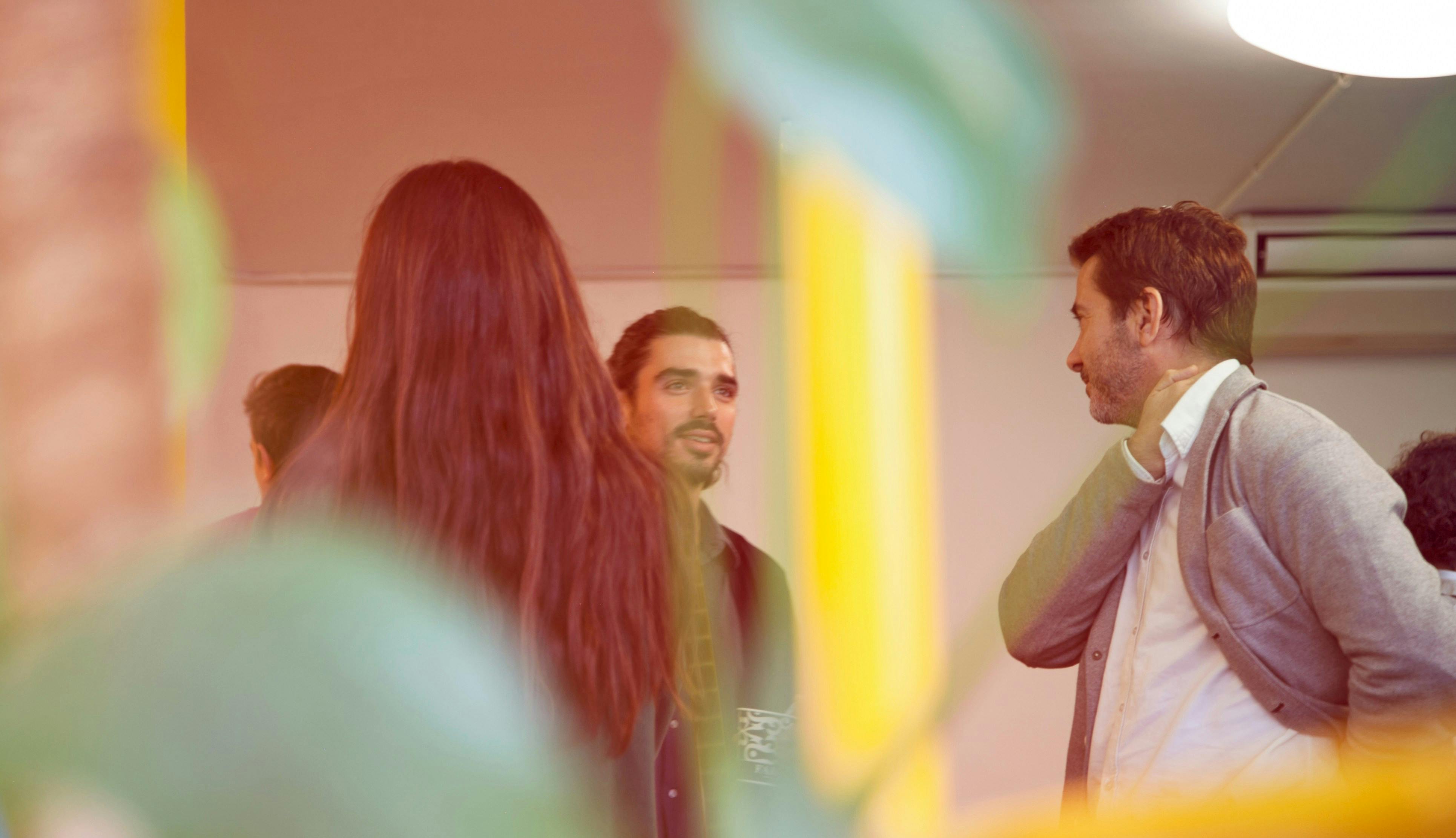 Photo through a colored glass window of business people talking