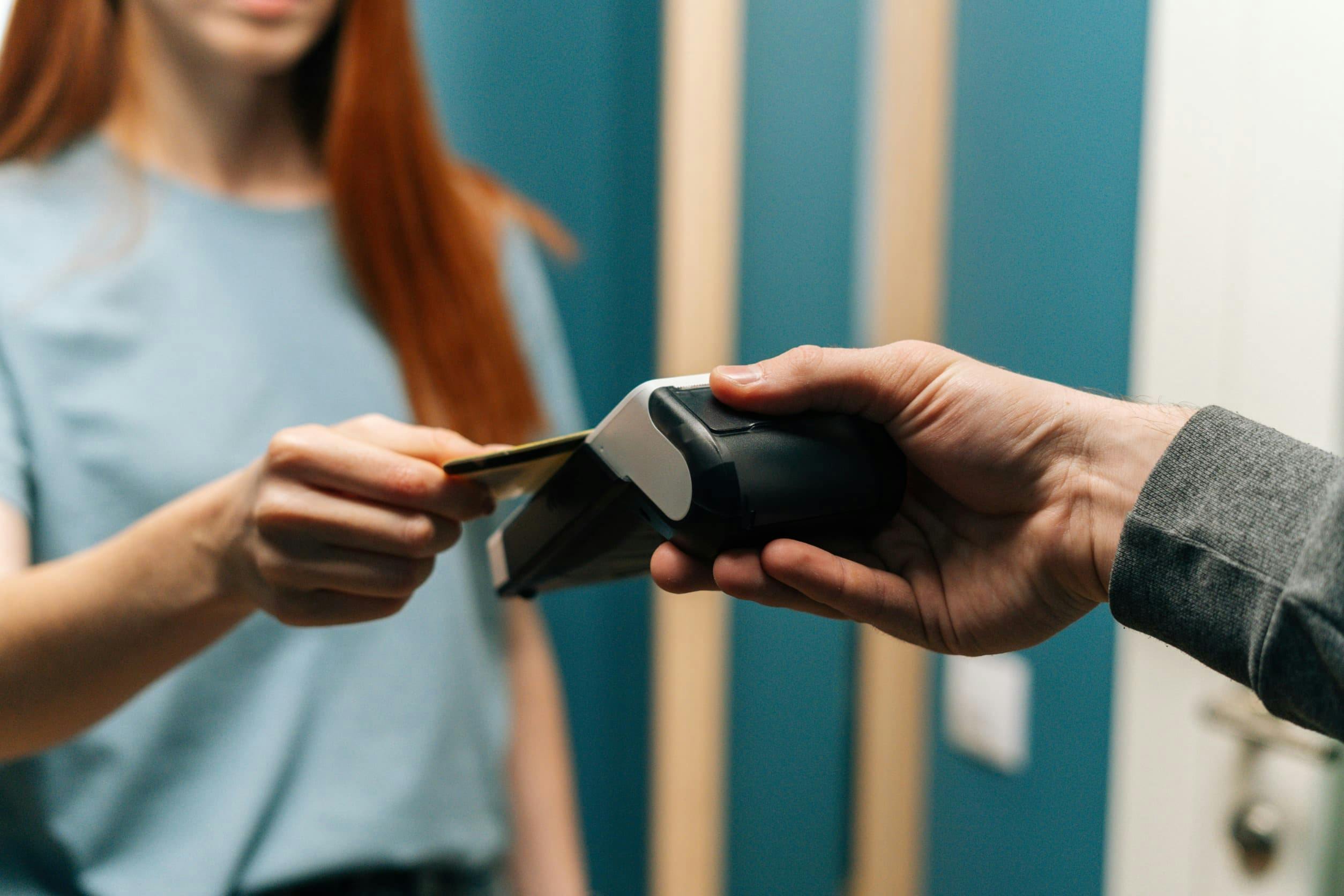 A woman paying with a debit card on a portable card reader