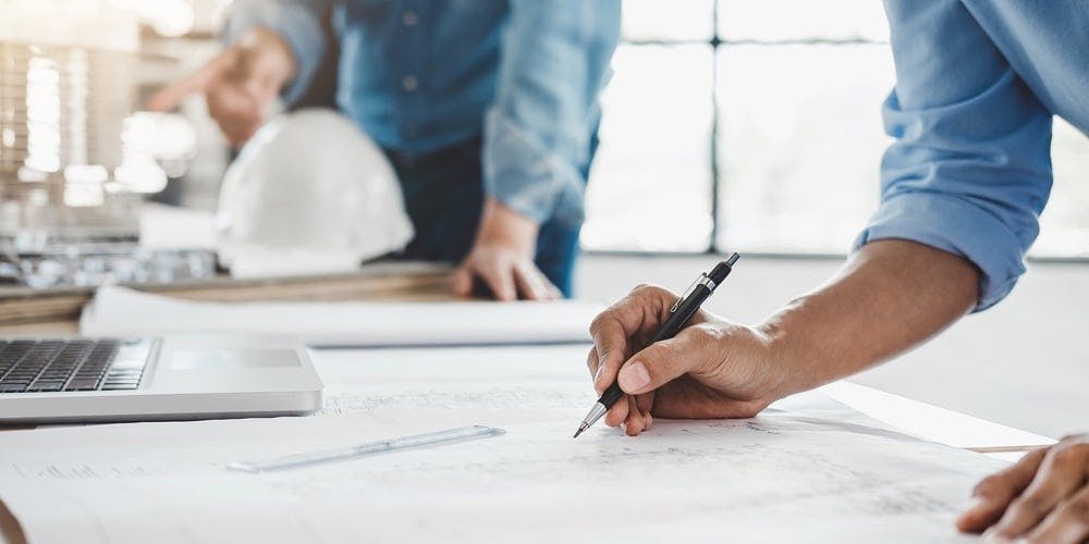 close up of hands working on building plan