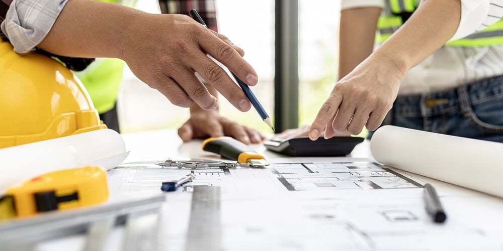 hands surveying over a building layout