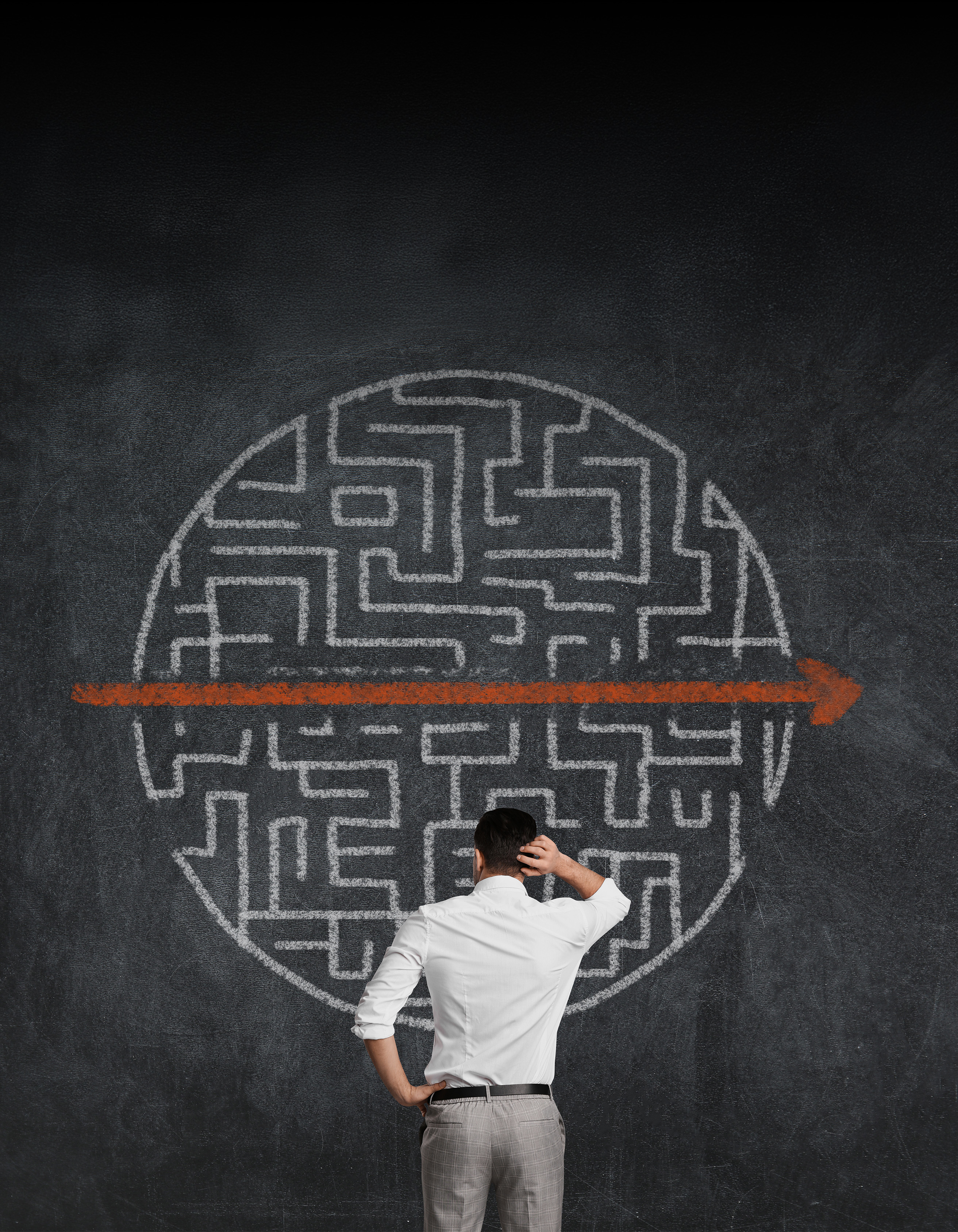 Person standing in front of complex chart with arrow cutting through it.