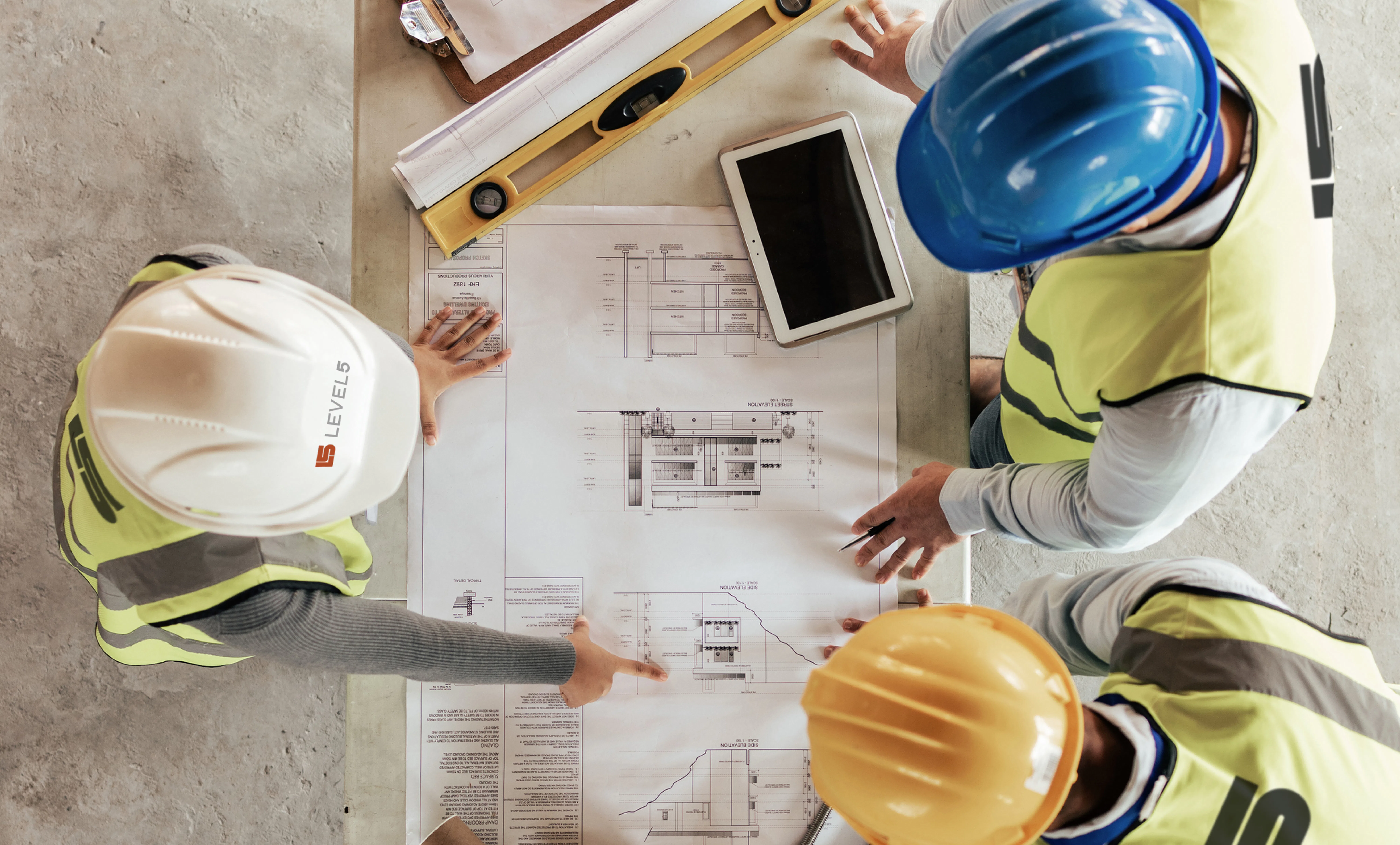 Construction workers gathered around a blueprint