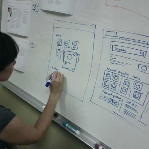 Person drawing website concepts on a whiteboard