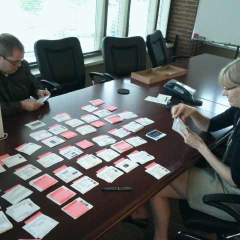 Man and woman seated at the conference room table reviewing documents