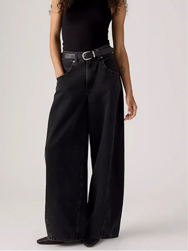 Woman in black relaxed-fit jeans and sleeveless top showcasing loose and baggy streetwear style.