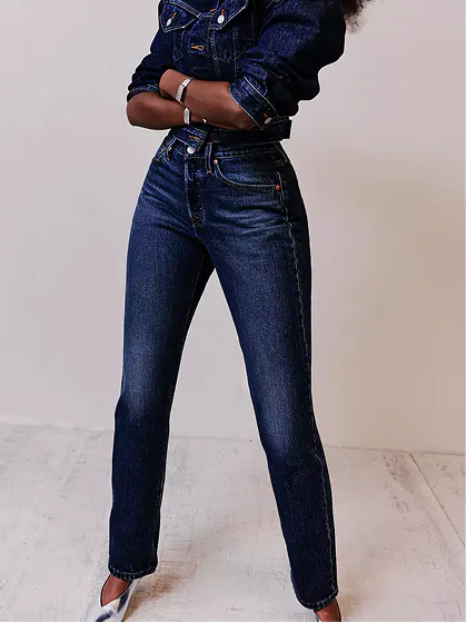 Woman wearing classic straight-leg dark blue jeans and heels.