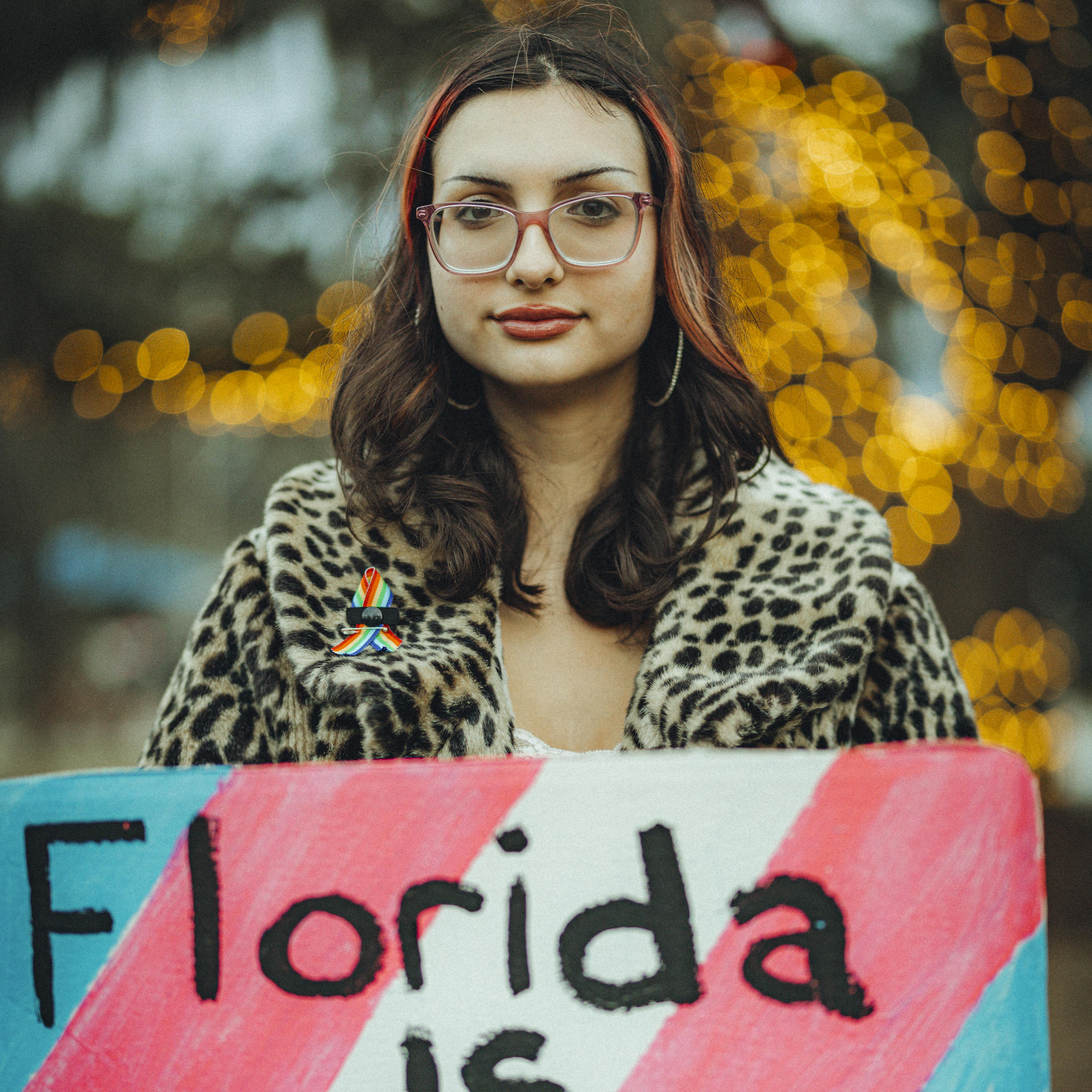 A girl is holding a sign in front of her.
