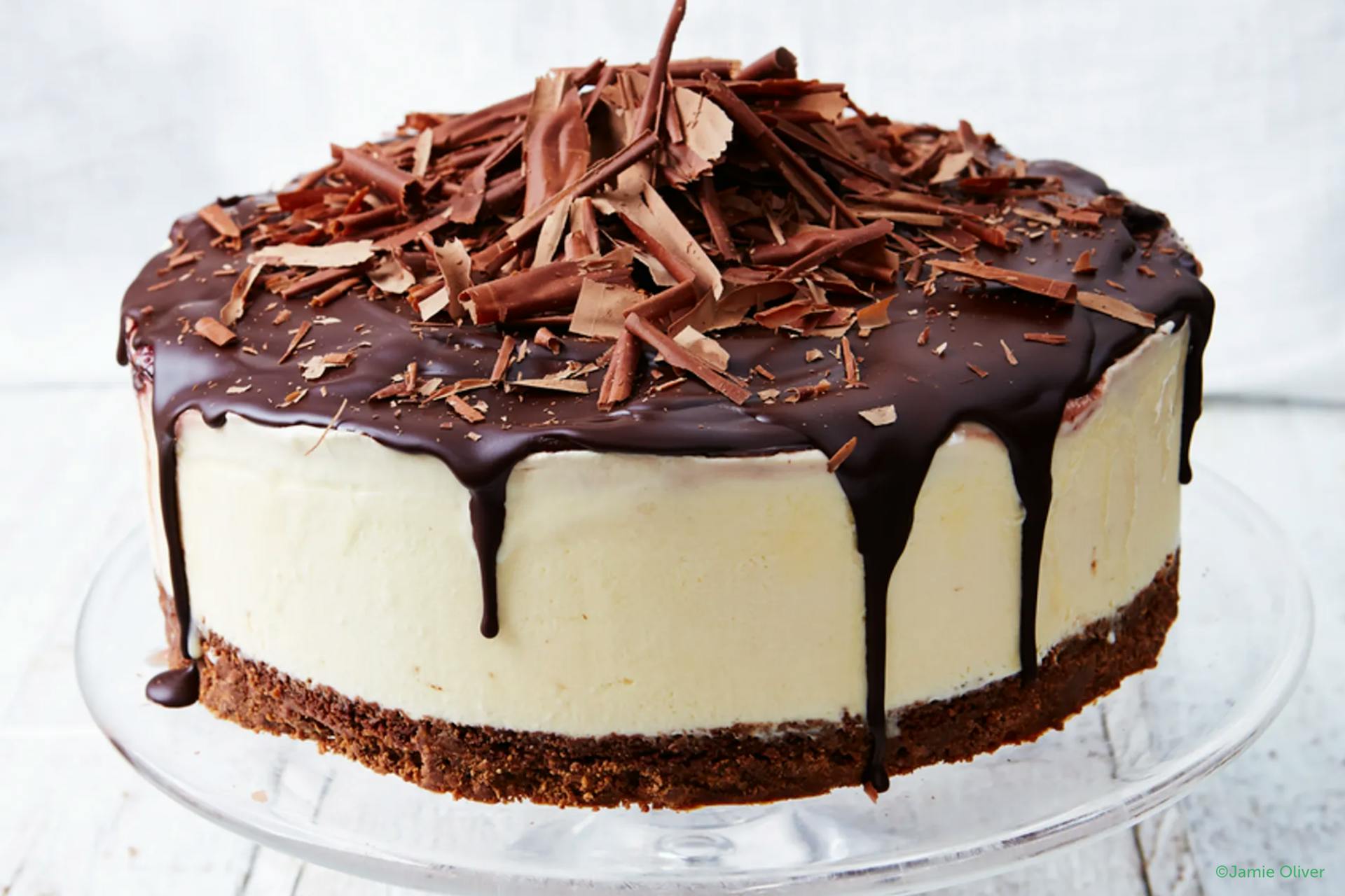 cheesecake met krokante bodem en versierd met lopende chocolade en schilfers