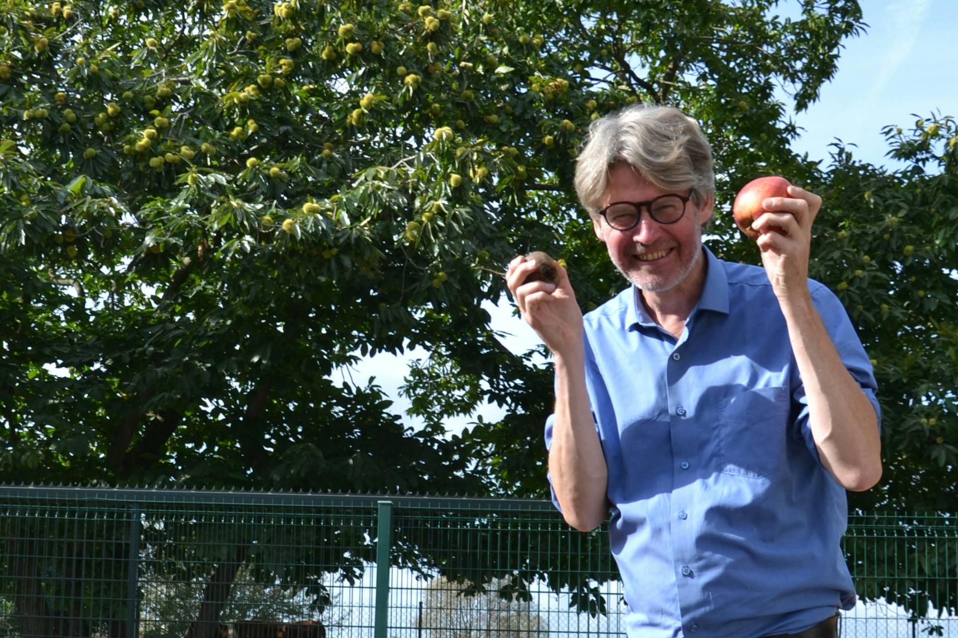 Portret foto van Jan Vanhuysse met een rode biet en appel in zijn handen