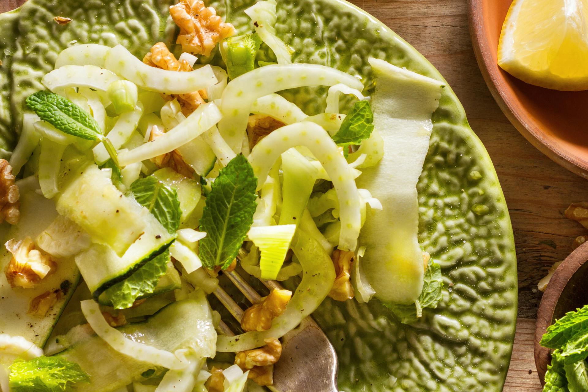 Foto van groen bord met gedreseerde salade van venkel en sinaasappel