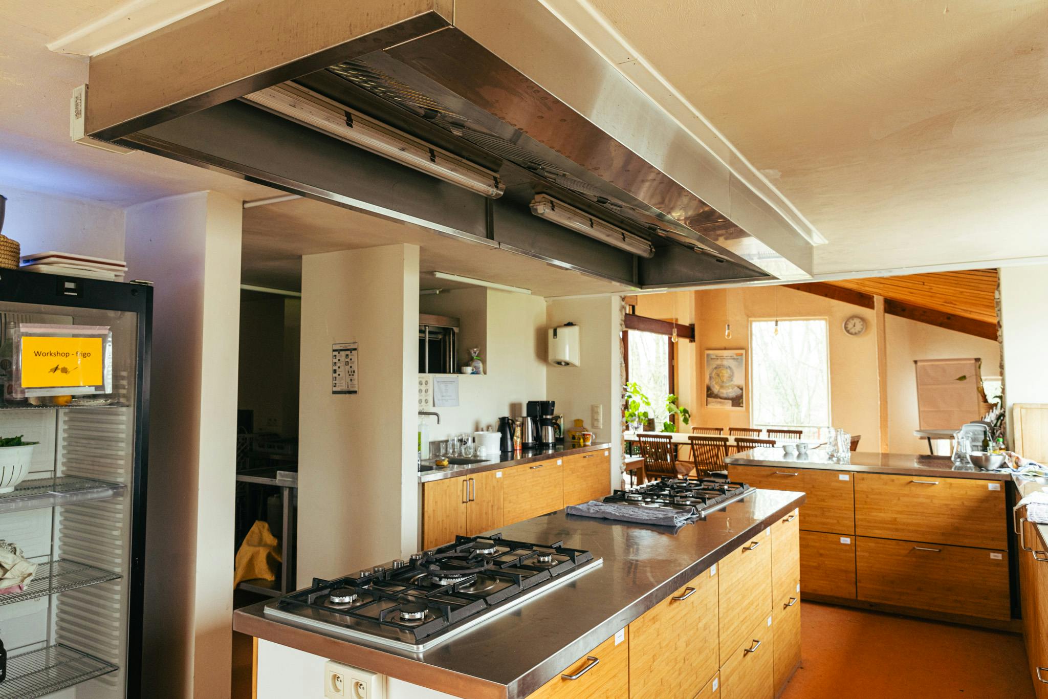 Zicht op de uitgeruste keuken met de zaal op de achtergrond