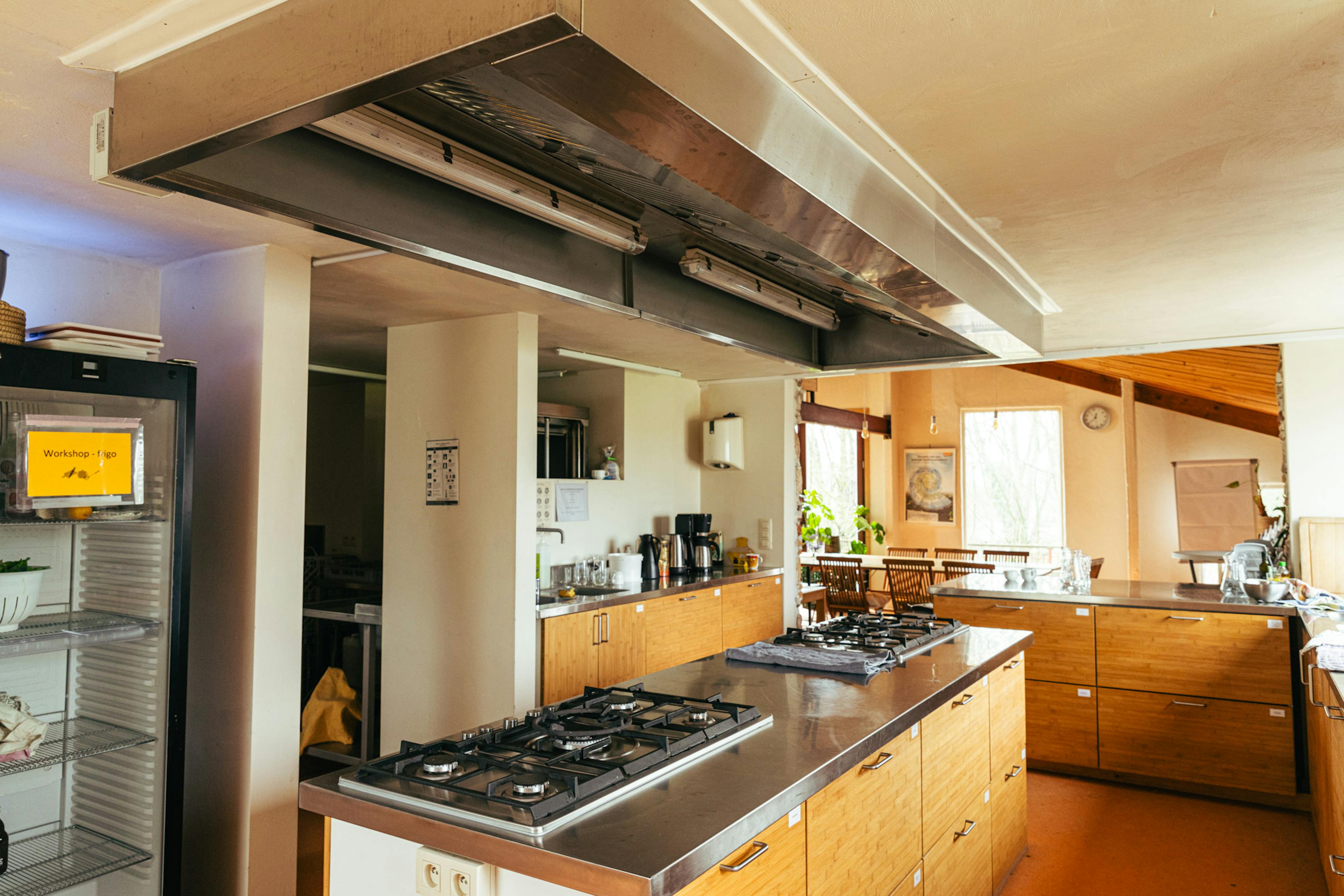 Zicht op de uitgeruste keuken met de zaal op de achtergrond