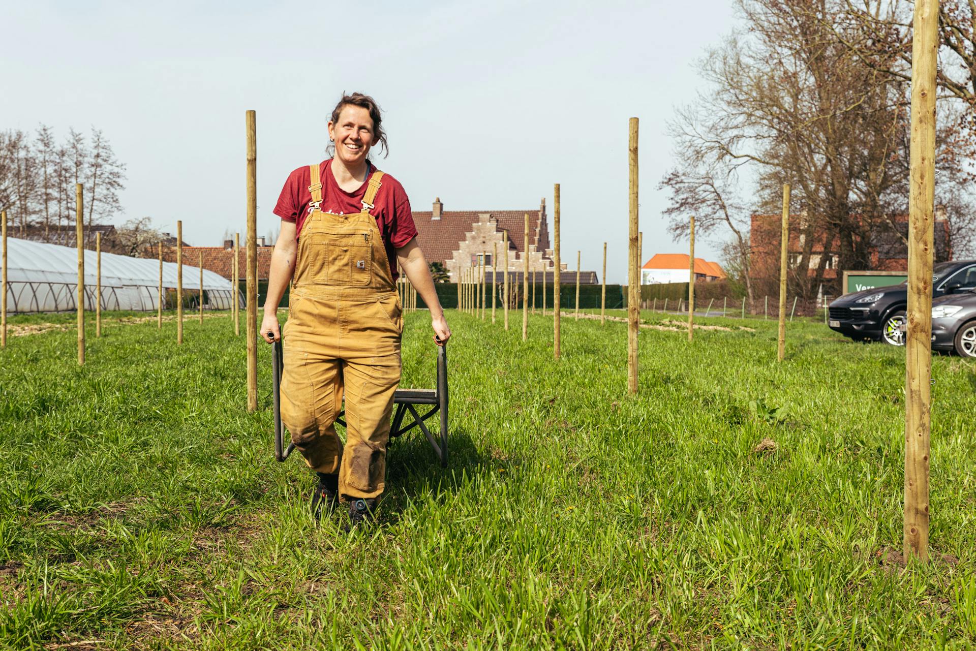 Foto van Cies op het veld die een kruiwagen achter zich trekt