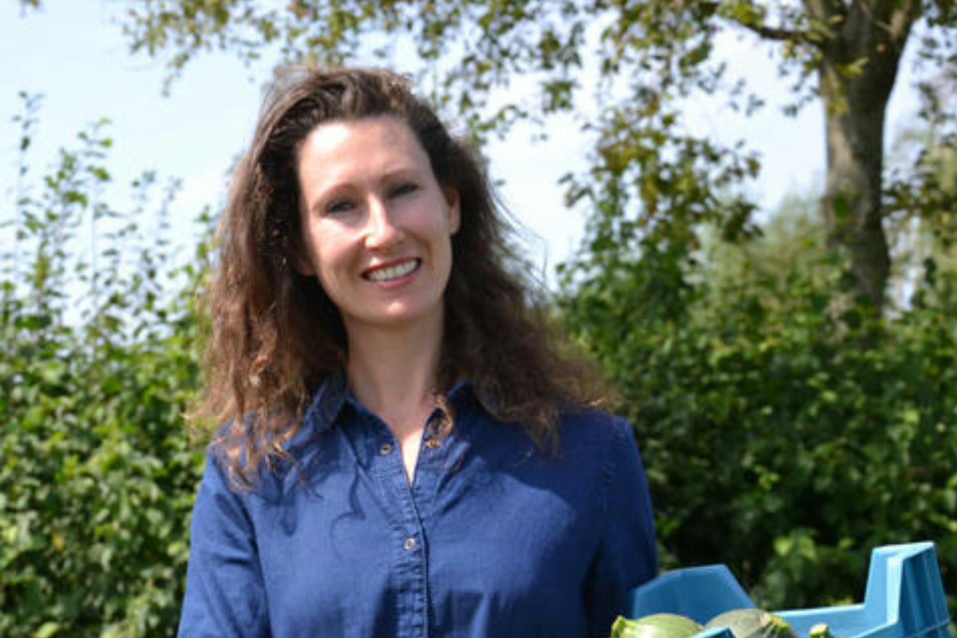 Nathalie buiten met een bakje groenten in haar armen