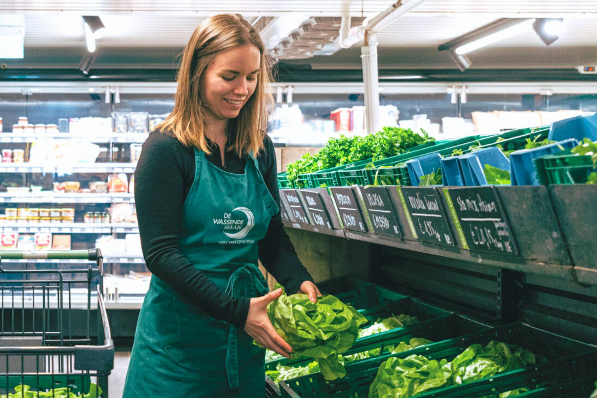 Foto van een winkelmedewerkster in de koelcel van de winkel van De Wassende Maan