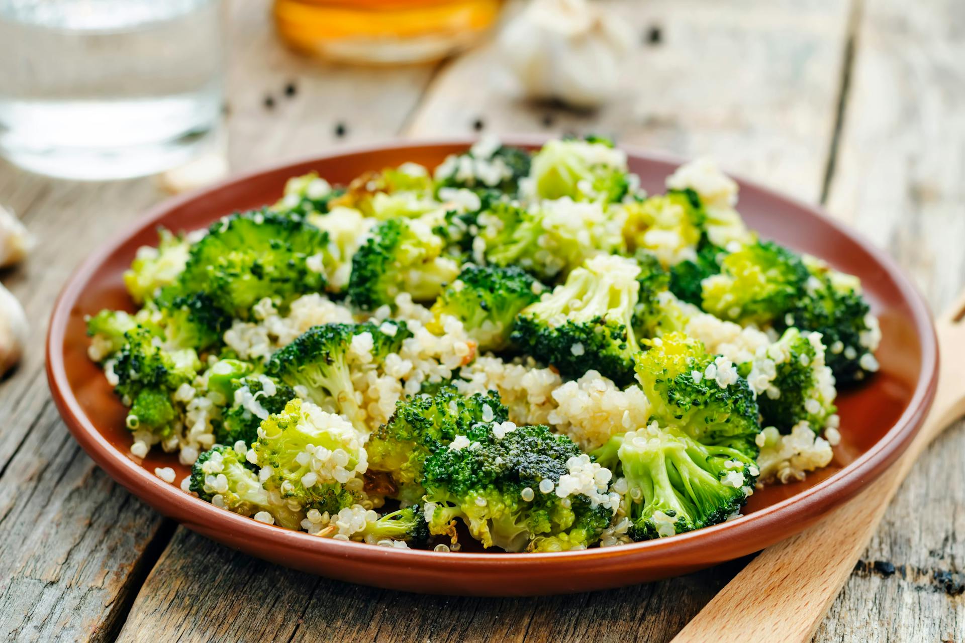 Quinoa salade met broccoli en pesto op een terracotta bord