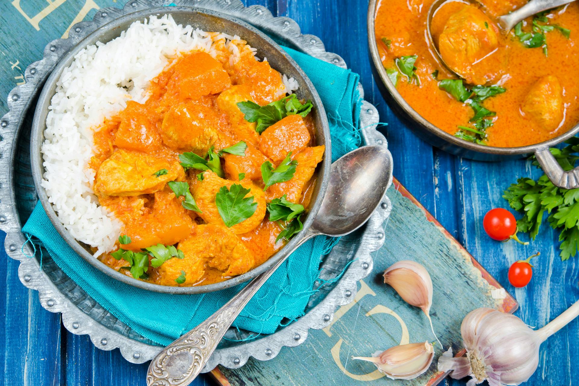kom met curry en rijst op blauw gedekte tafel