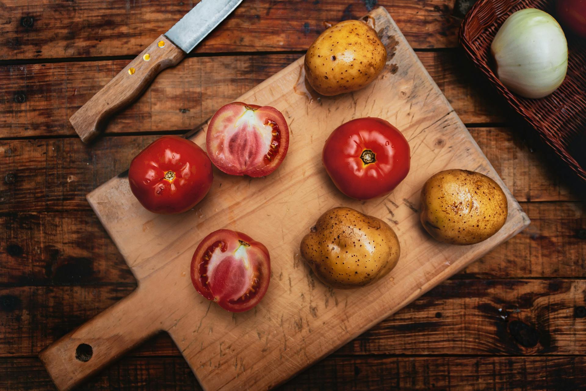 houten snijplank met tomaat en aardappel