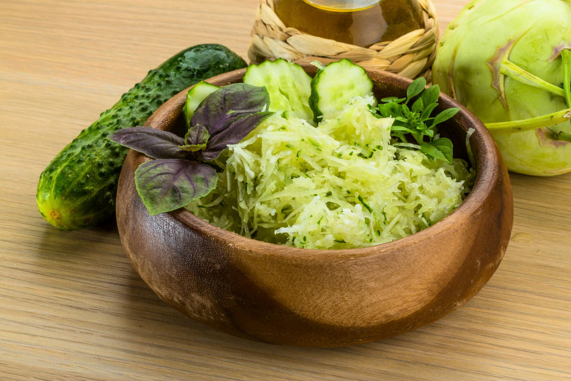 Houten kom met komkommer en koolrabi salade