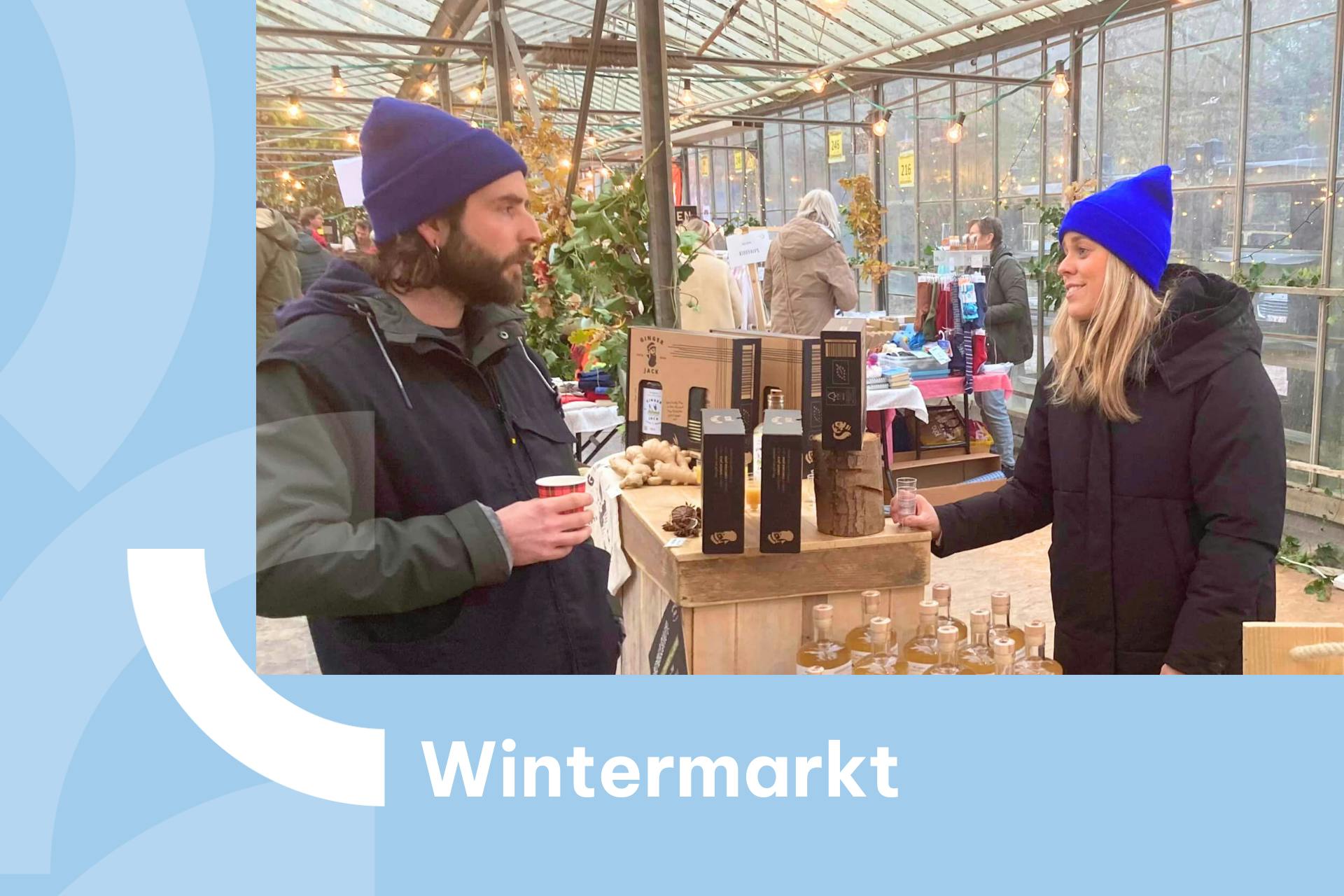Banner met foto van twee mensen met blauwe mutsen op de wintermarkt van De Wassende Maan