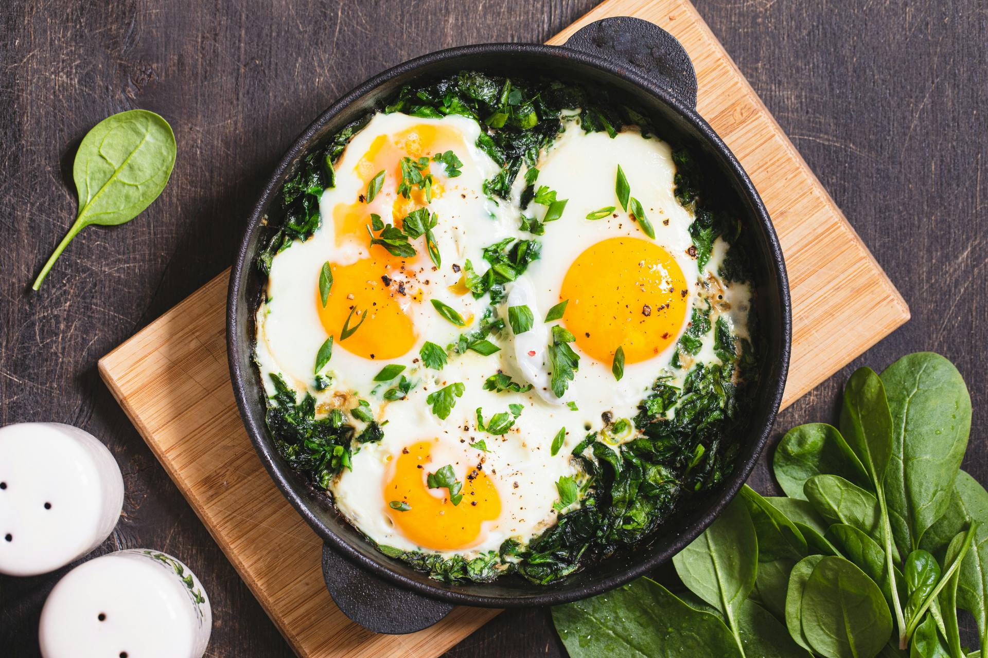 Groene shakshuka met spinazie op de pan