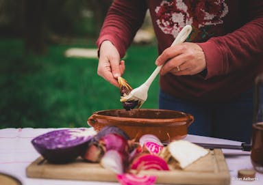 Banner met foto van Lieve Ferdinande, De Plantenkok, tijdens een kookworkshop in openlucht
