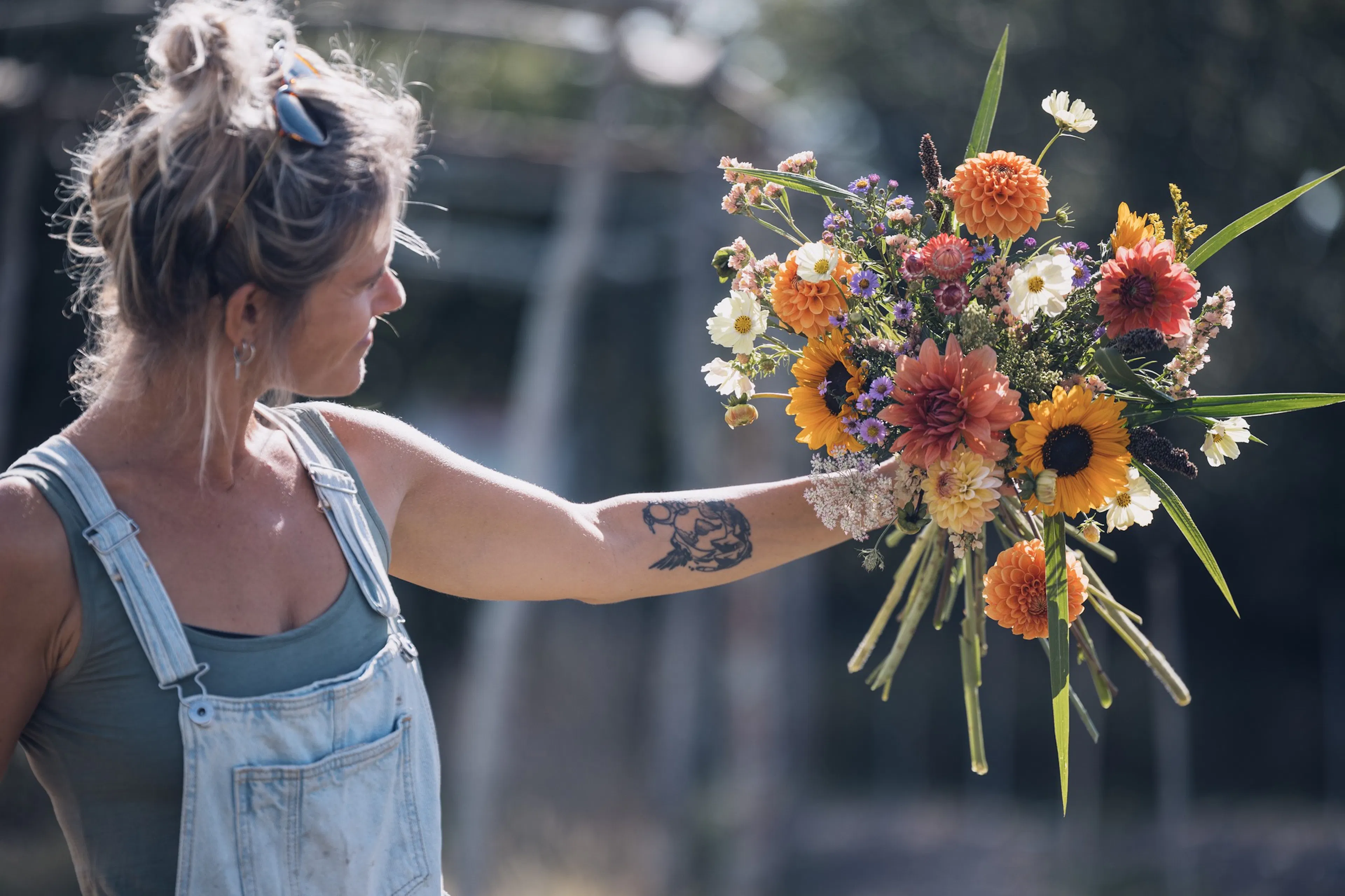 Foto van bio bloemenboerin Anais van Bloemenwij met een zomers bioboeket recht van het veld