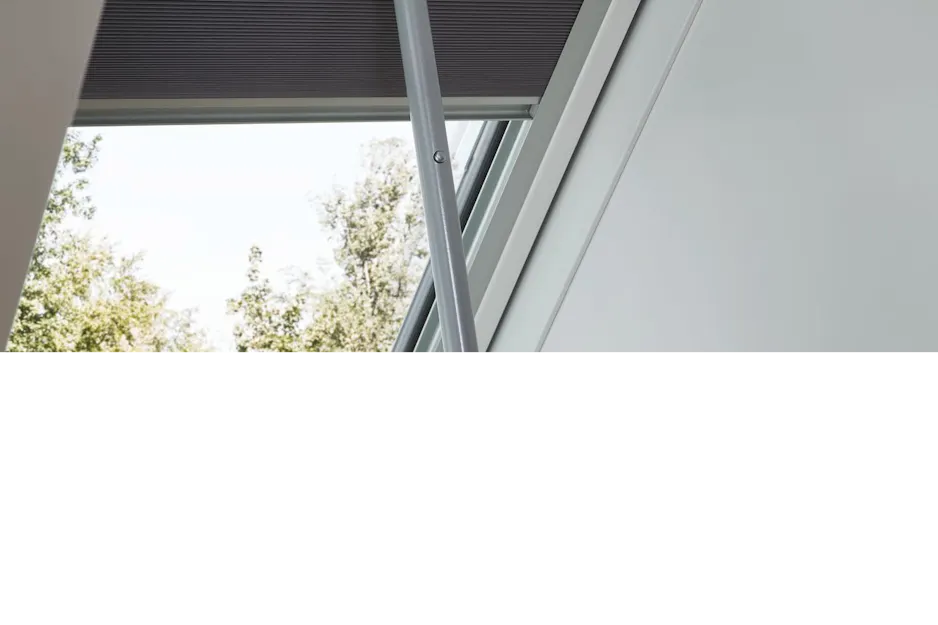 Innenrollo am Roto Dachfenster wird mit einer Bedienstange bedient Innenrollo am Roto Dachfenster wird mit einer Bedienstange bedient