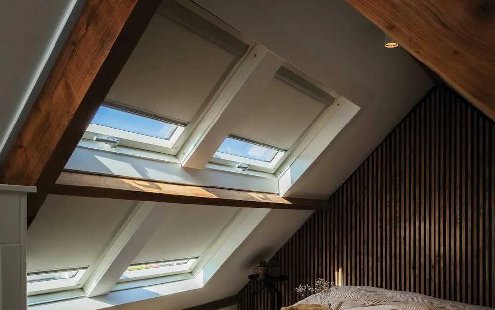 Schlafzimmer mit Holzbalken und FAKRO Dachfenstern mit Verdunkelungsrollos Schlafzimmer mit Holzbalken und FAKRO Dachfenstern mit Verdunkelungsrollos