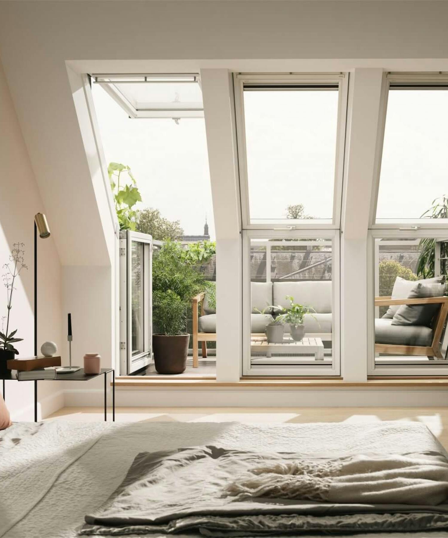 Velux Dachfenster mit geöffnetem Balkonfenster in modernem Schlafzimmer mit Zugang zur Dachterrasse Velux Dachfenster mit geöffnetem Balkonfenster in modernem Schlafzimmer mit Zugang zur Dachterrasse
